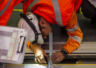 An engineer is testing the door of the train and platform screen door with a scale