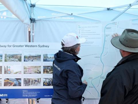 A Sydney Metro employee showing member of the community a map