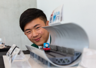 Close up shot of a male student posing with his submission for the Metro Minds STEAM Challenge 2019.