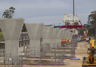 The segments for the skytrain are being put into place by heavy machinery.