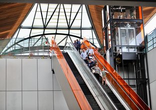 Several people are riding down the escalators at Norwest Station.