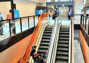 A family of four are riding up the escalators at Norwest Station.