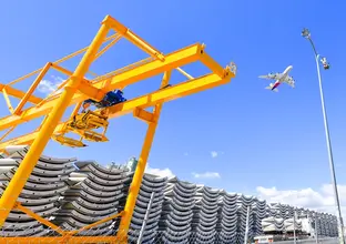 A close up shot of the precast segments piled and lined up ready for installation at Sydney Metro's Marrickville Station the picture is showing a crane above the segments and a plane flying overhead.