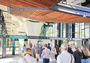 A crowd of people are walking inside the opal turnstyles at Rouse Hill Station on Community Day.
