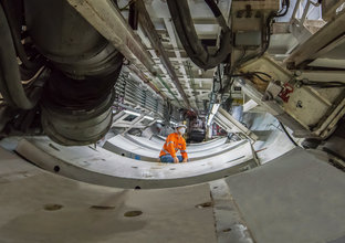 An on the ground view of a construction worker between concrete slabs as part of the tunnelling construction under Sydney Metro's Waterloo Station. 