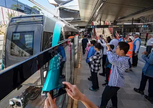 A crowd of people on Cherrybrook Station platform waiting for the platform screen doors to open.