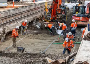 Construction workers in high viz working on reinforcing the railway track which is above the future central walk