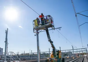 A close up view of construction workers on a cherry picker lift as the overhead works continue as part of the expansion of the Sydney Metro Trains Facility in Rouse Hill.