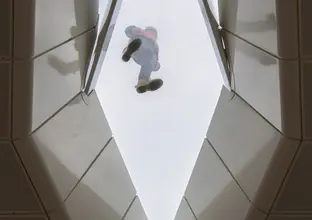 Looking up at Central Station vaulted roof. A construction worker is seen standing on top of the glass roofing 