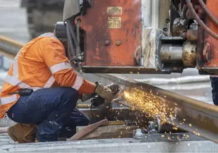 A construction worker in high viz welding train track at Waterloo