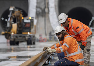 Two construction workers inspecting the rail track at Waterloo Station