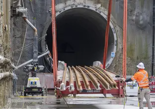 A construction worker moving trail track into the tunnel opening at Waterloo Station