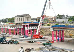 A wide shot of the aqueduct at Sydenham during construction. A large crane and heavy machinery are on site.