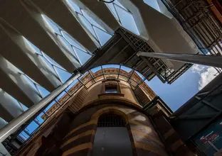 A view from below of the new canopy roof enhancing the heritage aesthetics of Central Station. The blue sky can be seen through the glass panels.