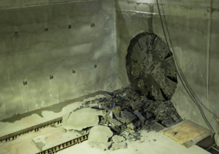 The cutterhead on tunnel boring machine Elizabeth can be seen breaking through the wall in the  station box cavity