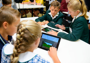 A group of students working in pairs using tablets as part of the school competitions of Sydney Metro's FastTracking the Future initiative. 