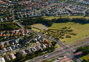 A bird's eye view showing rows of houses and a park in the suburb of Kellyville.