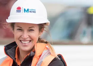 Close up photo of woman in Sydney Metro hard hat and high vis jacket (PPE )