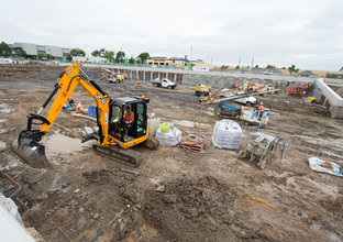 A man works inside a digger on the Bella Vista Station construction site.