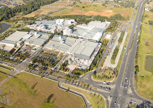 An aerial view of Rouse Hill Station surrounded by green fields and trees.