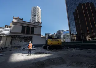 An on the ground view showing a construction worker inspecting the demolition site at Sydney Metro's Martin Place Station.