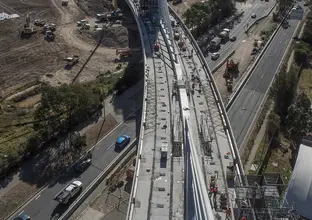 A bird's eye view of Sydney Metro's Windsor Road bridge being constructed, there are cars traveling on the road below.