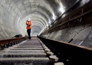 An on the ground view of a construction worker completing track work inside the first Sydney Metro tunnel track. 