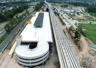 A bird's eye view looking down at the multi-story carpark build next to the train tracks leading to Sydney Metro's Kellyville Station. 