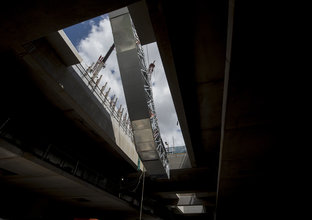 An on the ground view looking up at the escalators being craned into place at Sydney Metro's Norwest Station.