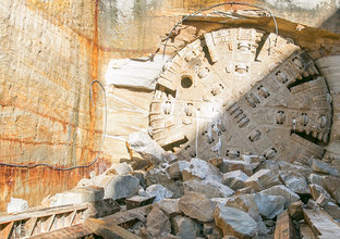 An on the ground view showing Tunnel Boring Machine (TBM) 1 Elizabeth breaking through the stone at Sydney Metro's Hills Showground Station. 