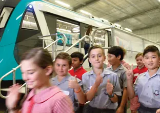 A group of students shown walking past a Sydney Metro train as part of the FastTracking the future education program.