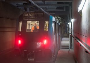 A Sydney Metro train being tested by two Sydney metro employees inside a tunnel. 