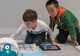 Two students participating in the fun with robots workshop as part of Sydney Metro's Education Program. 