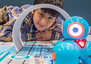 A student poses with a robot while participating in the fun with robots workshop as part of Sydney Metro's Education Program. 