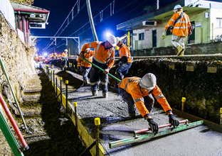 An on the ground view of construction workers laying the concrete on the tracks at Sydney Metro's Wiley Park Station.