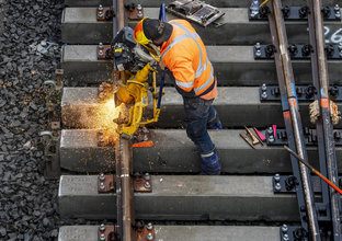 Sparks fly as construction workers use a grinder on the metal tracks at Bankstown Station.