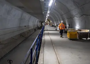 A construction worker walks down the underground tunnel inside Pitt Street Station Cavern.