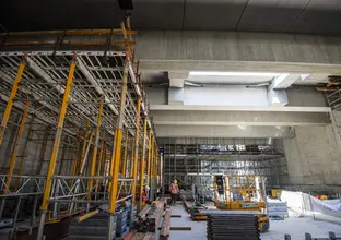 A view of the construction happening beneath the concourse level as the ceiling of the future station platform takes shape.