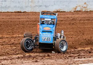 A blue race car spins out in the dirt track at the new Eastern Creek Speedway.