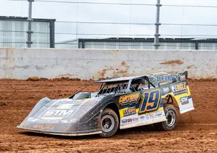 A yellow and black race car drives in the dirt track at the new Eastern Creek Speedway.