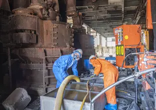 Two construction workers working at White Bay Power Station in full PPE suits