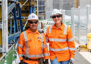 Two construction workers smiling on site on B3 level at Sydney Metro's Waterloo Station. 