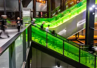 Ground level view of passengers using the stairs and escalators at Sydney Metro's Rouse Hill Station.