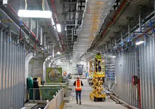 Construction worker walking through the underground caverns at Sydney Metro's Martin Place Station.