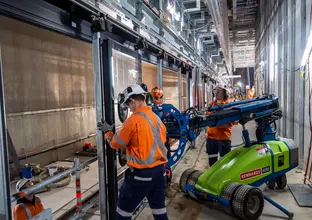 Construction workers and machinery used to install platform screen doors at Sydney Metro's Waterloo Station