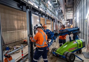 Construction workers and machinery used to install platform screen doors at Sydney Metro's Waterloo Station