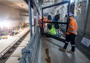 Construction workers installing platform screen doors at Sydney Metro's Waterloo Station