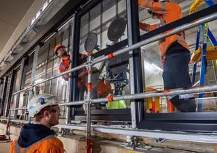 Construction workers installing platform screen doors at Sydney Metro's Waterloo Station