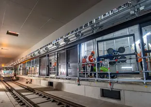 Construction workers installing platform screen doors at Sydney Metro's Waterloo Station