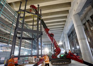 Steel structures are craned into position inside Barangaroo Station's underground cavern